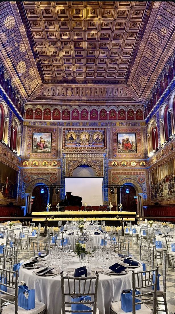 Cena de gala con escenario y pantalla