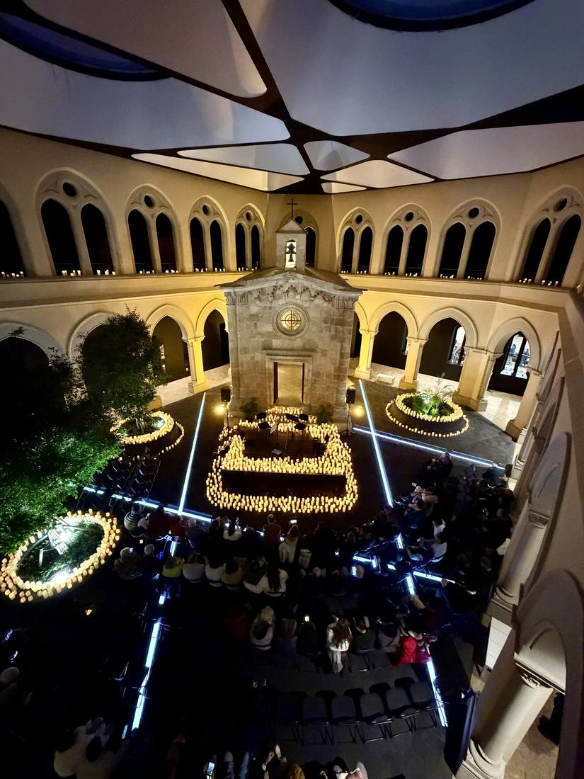 Patio histórico iluminado de noche con velas y luz arquitectónica