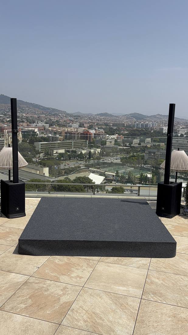 Tarima y torres de sonido en una terraza con vistas a la ciudad